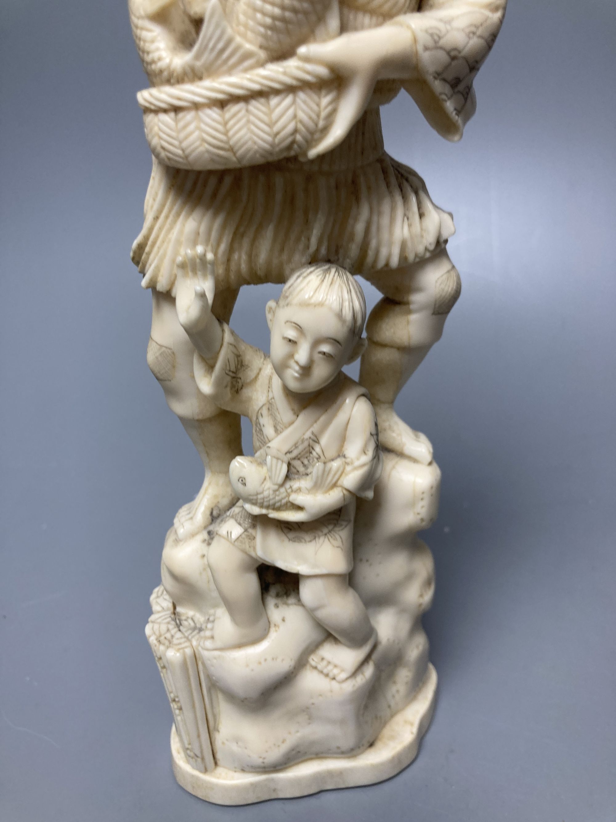 A Japanese walrus ivory okimono of a fisherman and boy, height 30cm